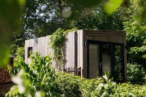 a small building with a door in a garden at Boshuisje Zelhem in Zelhem