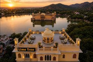 a mansion on the water with a line tree at Lime Tree Hotel & Banquet Jal Mahal Jaipur in Jaipur