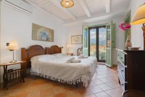 a bedroom with a bed and a large window at Case Saponara in Cefalù