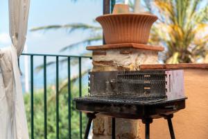 a grill on a balcony with a pot on top at Case Saponara in Cefalù
