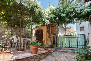 a garden with a gazebo with white flowers at Case Saponara in Cefalù
