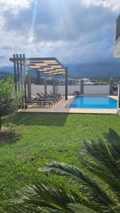 a view of a swimming pool with chairs and a pavilion at KALİDA APART in Kemer