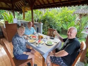 a group of people sitting at a table eating food at Pondok Indah Homestay in Sidemen