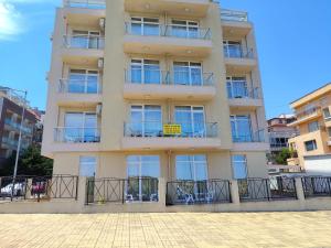 an apartment building with balconies and tables and chairs at Амон Ра 2 in Primorsko