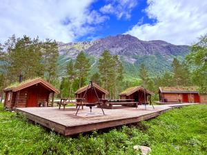 a wooden deck with a picnic table and some huts at Camp Dronningkrona in Ålvundeid