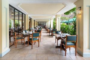 a restaurant with wooden tables and chairs and windows at Nairobi Serena Hotel in Nairobi