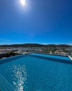 a large swimming pool with a view of the ocean at Samba Bossa Nova Cabo Frio in Cabo Frio +21 photos