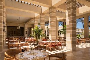 a restaurant with tables and chairs in a building at Sakhra Hotel & Spa, Almaza Bay in Marsa Matruh