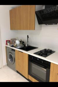 a kitchen with a stove and a washing machine at Appartement Hergla in Harqalah +6 photos