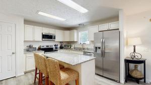 a kitchen with white cabinets and a stainless steel refrigerator at Piney Glade - 18628 Sylvan Dr in Rehoboth Beach