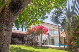 a villa with a pool and a yard with trees at Vila hangloose vista da lagoa in Acaraú