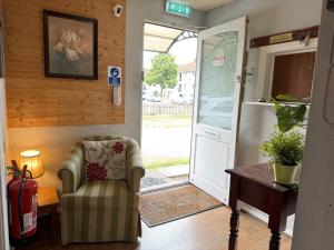 an open door with a chair and a fire extinguisher at Charde Guest House in Birmingham