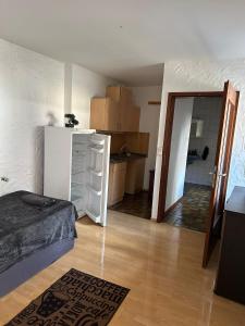 a room with a bed and a refrigerator and a kitchen at Landhaus Butzbach in Butzbach