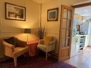 a living room with two chairs and a table at Charde Guest House in Birmingham