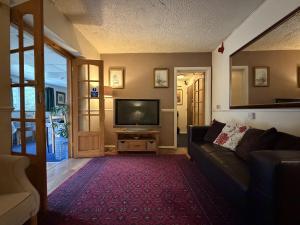 a living room with a couch and a television at Charde Guest House in Birmingham +4 photos