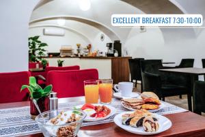 a table with plates of breakfast food and orange juice at BlueBell Hotel in Bratislava +29 photos