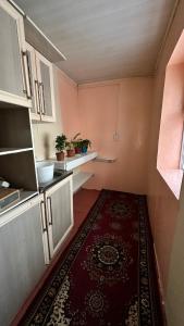 a small kitchen with a rug on the floor at datkaguesthouse in Kochkorka +14 photos