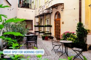 an outdoor patio with tables and chairs and plants at BlueBell Hotel in Bratislava
