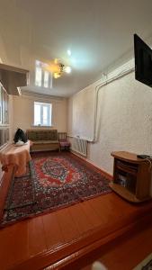 a living room with a couch and a large rug at datkaguesthouse in Kochkorka