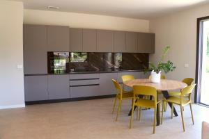 a kitchen with a wooden table and yellow chairs at Villa Grace in Padenghe sul Garda