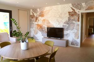 a living room with a table and a tv on a wall at Villa Grace in Padenghe sul Garda