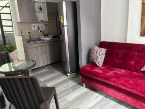 a living room with a red couch and a table at San Joaquín B&B in Cali