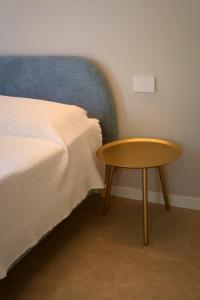 a bed with a wooden table next to a bed with a bedskirts at Villa Grace in Padenghe sul Garda +18 photos