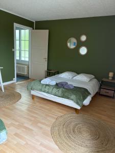 a bedroom with a large bed with green walls at Hôtel L'escale des Hayons in Esclavelles +30 photos