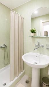 a bathroom with a sink and a shower curtain at Apartments Taida in Dobra Voda +43 photos