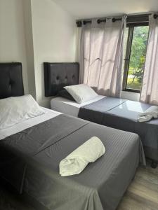 a bedroom with two beds with a pillow on it at San Joaquín B&B in Cali