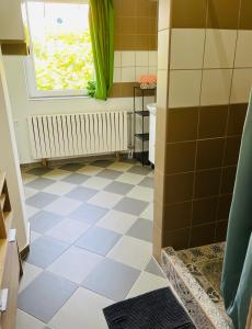 a bathroom with a tiled floor and a window at Téesz Vendégház in Zalaháshágy