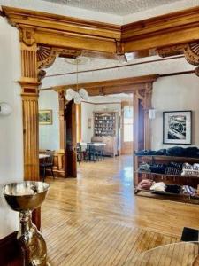 a living room with a wooden floor and a dining room at Garfield Inn in Port Austin