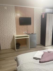 ein Schlafzimmer mit einem Bett und einem Fernseher an der Wand in der Unterkunft AnA in Constanţa