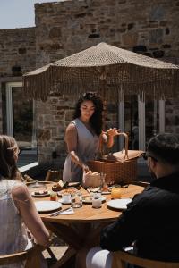 a woman standing in front of a table at Naxian Rhapsody Luxury Villas in Stelida