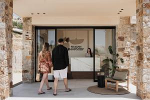 two people standing in front of a store window at Naxian Rhapsody Luxury Villas in Stelida