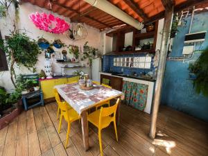 a kitchen with a table and some yellow chairs at Hospedaria de Maria in Salvador