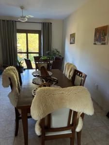 a dining room table and chairs with a rug on it at Refúgio Aroma do Campo in Bagé