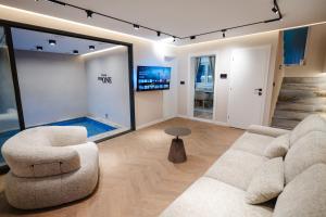 a living room with two chairs and a flat screen tv at Villa The One Mostar with Heated Pool & Jacuzzi in Mostar