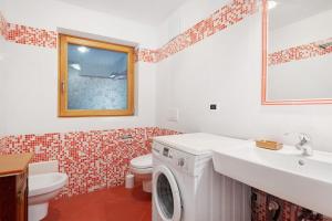 a bathroom with a washing machine and a sink at Appartamenti Boé 1 in Livinallongo del Col di Lana +19 photos