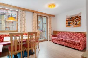 a living room with a table and a red couch at Appartamenti Boé 1 in Livinallongo del Col di Lana