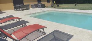 a swimming pool with two chairs and a table at Maison de vacances avec piscine in Soustons +20 photos