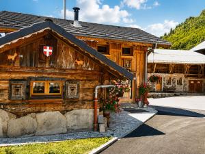a wooden house with a red cross on it at La R'mise in Montriond