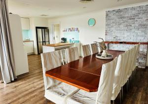 a kitchen and dining room with a wooden table and chairs at 100m to Beach&Shop Spacious Pristine One Story Family Home in Batemans Bay