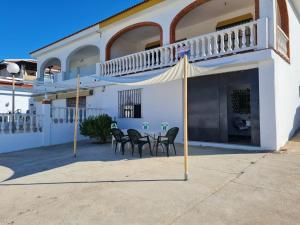 a patio with chairs and a table in front of a building at PUESTA DE SOL-Matalascañas in Matalascañas