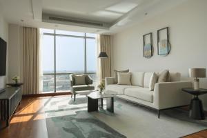 a living room with a couch and a chair at Fraser Suites Seef Bahrain in Manama