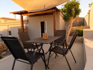 a wooden table and chairs on a patio at Casa Thea in Archangelos