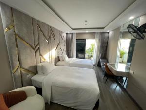 a hotel room with two beds and a desk at Lavie Hotel in Hanoi