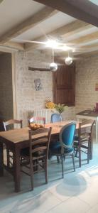 a dining room with a wooden table and chairs at Le Gîte et le Couvert in Bellefoye