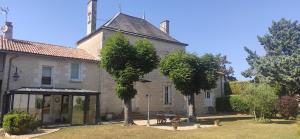 an old house with trees in front of it at Le Gîte et le Couvert in Bellefoye