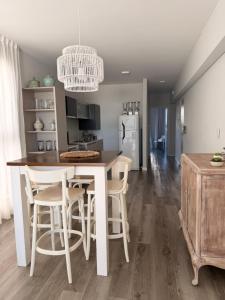 a kitchen with a table and chairs and a refrigerator at Depto cálido y moderno in San Nicolás de los Arroyos +5 photos